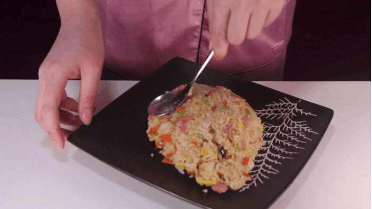 蛋包饭的创新吃法，上桌大家都不忍心动筷子,接着借助勺子将米饭按压成一个菠萝的形状。