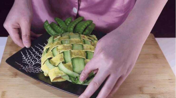 蛋包饭的创新吃法，上桌大家都不忍心动筷子,稍微调整一下，让蛋皮完全包裹住米饭，接着在“菠萝”头部的部分放上烫熟的荷兰豆装饰成菠萝叶子的形状。