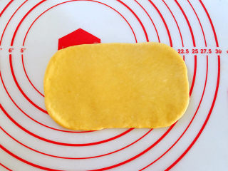 南瓜麻薯红豆面包,取1个面团，收口朝下，用手拍扁排气后，擀成椭圆形。