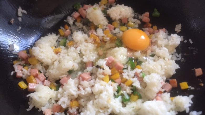 扬州蛋炒饭,倒入米饭，加入一个生鸡蛋