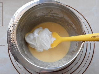 酸奶戚风蛋糕,取1/3蛋白霜放入蛋黄糊中，用刮刀快速翻拌均匀。
