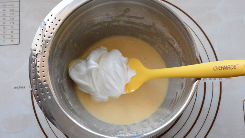 酸奶戚风蛋糕,取1/3蛋白霜放入蛋黄糊中，用刮刀快速翻拌均匀。
