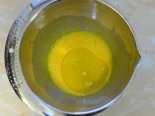 酸奶戚风蛋糕,搅拌好的蛋黄加入玉米油，搅拌至乳化状态