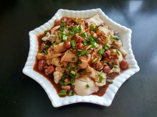吃鸡  口水鸡,将炸好的花生米放入盘中，再将刚才做好的酱料倒入，撒上香葱。
