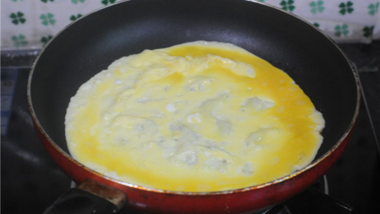 湖南+胡萝卜鸡蛋卷,平底锅放入少许油，将一半鸡蛋液倒入，晃动锅子，将蛋液摊成饼，煎至底部完全凝固