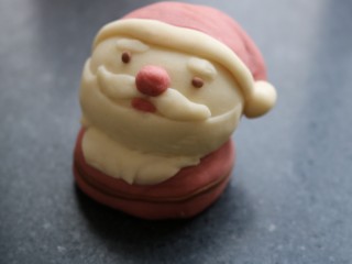 ≈卡通馒头之圣诞快乐🎄≈,用红色面团做一个圆球稍微压一下做身子。然后用可可面团给他做一个“腰带”和小眼睛👀，这样圣诞老公公🎅就做好了