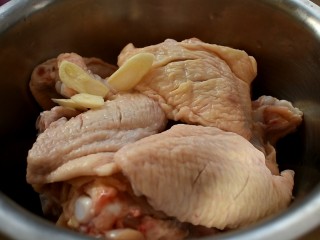 三汁焖锅,将蒜切成片，跟鸡翅放一起