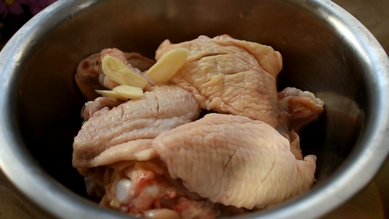 三汁焖锅,将蒜切成片，跟鸡翅放一起