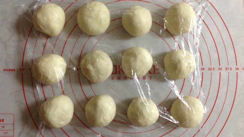 奶黄小餐包,然后把面团取出，平均分成12份，盖上保鲜膜松弛10分钟。