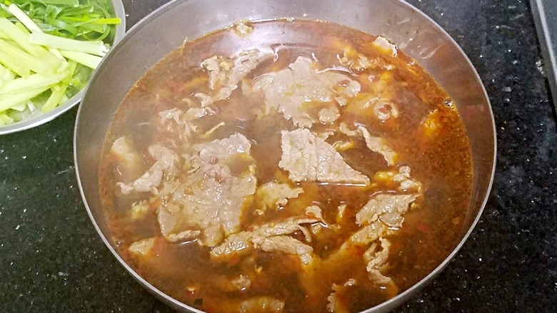 水煮牛肉,将牛肉连汤一起倒入盘中。