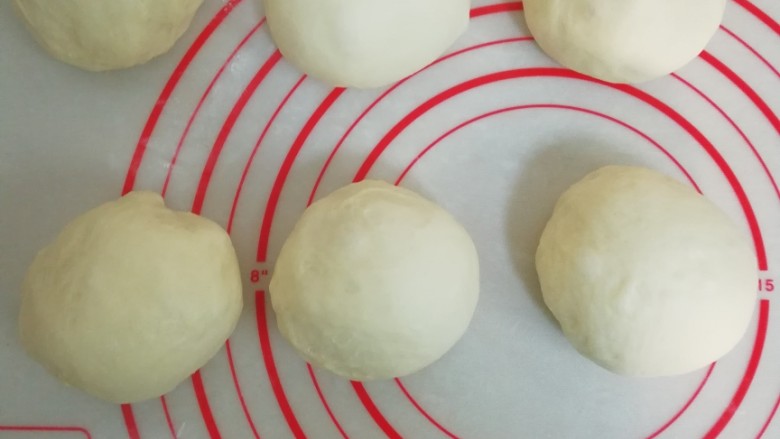 飘香椰蓉小花面包,揉面垫上撒点面粉，把面团平均分成6份，揉圆盖好保鲜膜静置15分钟。