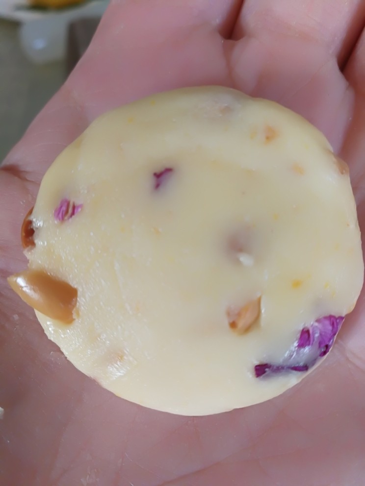 低油低糖植物油版玫瑰花瓣花生酥,将混合好的花生酥面胚分成10克左右一个，在手上搓圆后稍微压扁一点，放入烤盘上。