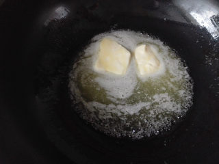 花生黑芝麻牛轧糖,黄油放到不粘锅里，开中火加热使之融化