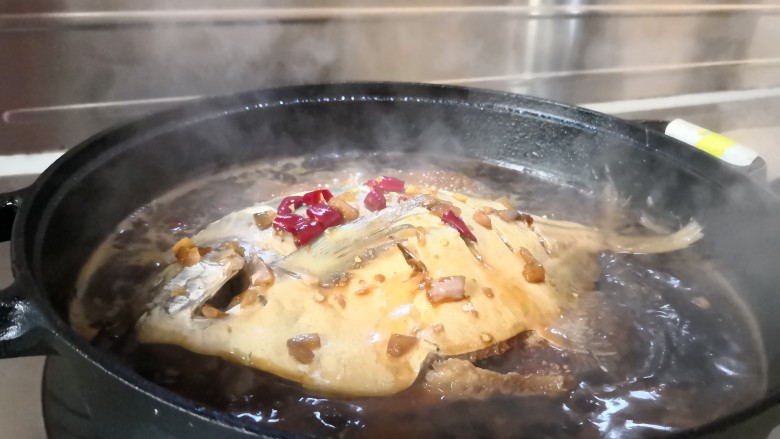 铁锅鲳鳊,中间看一下，用勺子把汤料反复往鱼身上撒，这样鱼肉会更加入味。