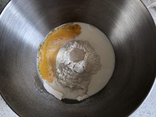 圣诞雪花面包,厨师机面盆内先倒入牛奶和打散的一个鸡蛋，然后倒入高粉和中粉，中间挖一孔倒入活性干酵母，盐和糖对角线放置