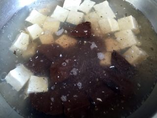 鸭血烧豆腐,锅中烧开水，放少许油，放入大豆腐和鸭血焯水2-3分钟