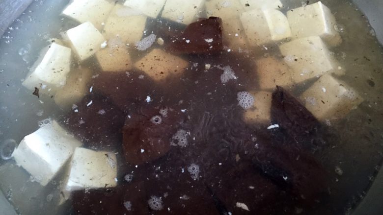 鸭血烧豆腐,锅中烧开水，放少许油，放入大豆腐和鸭血焯水2-3分钟
