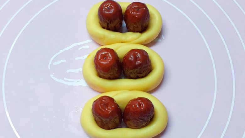 富贵花开枣花馍,如图：分别将长条首尾连接排在一起，（接口部分朝内）中间放上两颗红枣。