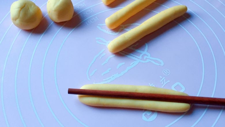 富贵花开枣花馍,再取中份面团均匀分成9等份，然后搓成8cm的长条，用筷子从中间压一条直线印痕。