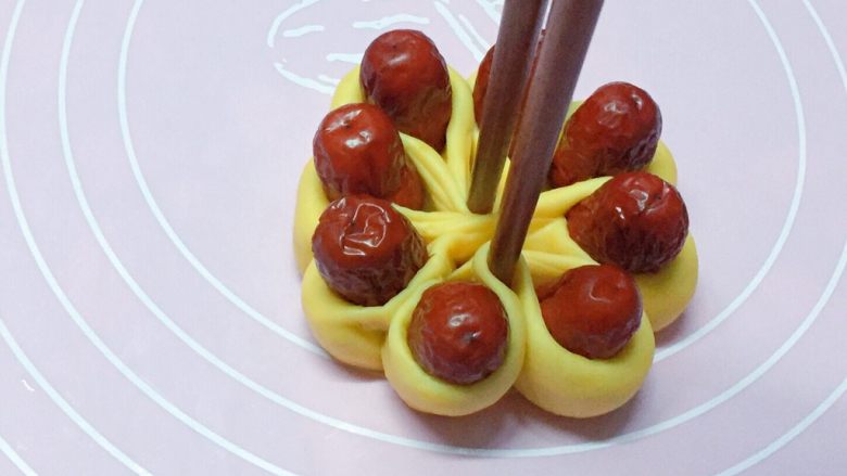 富贵花开枣花馍,如图：再用筷子从中间部位夹紧。