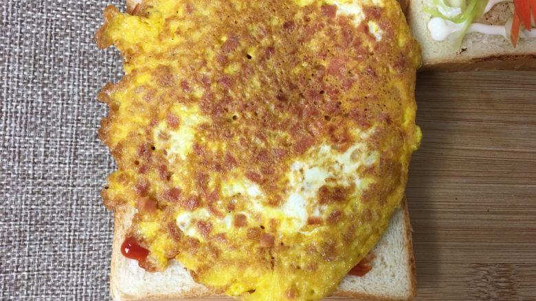 元气早餐三明治,在挤上番茄酱的面包片上放上鸡蛋