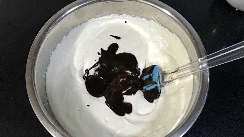 八寸巧克力慕斯巧克力淋面裱花蛋糕,倒入打发好的淡奶油盆里。