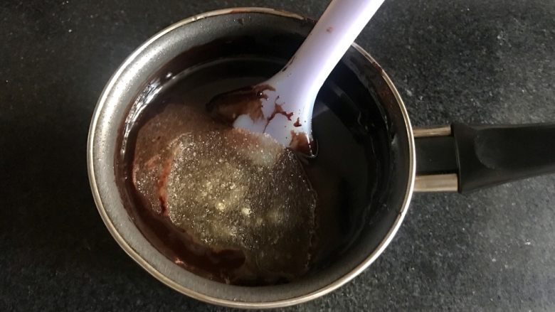 八寸巧克力慕斯巧克力淋面裱花蛋糕,趁热加入泡好的吉利丁粉，搅拌，融化。