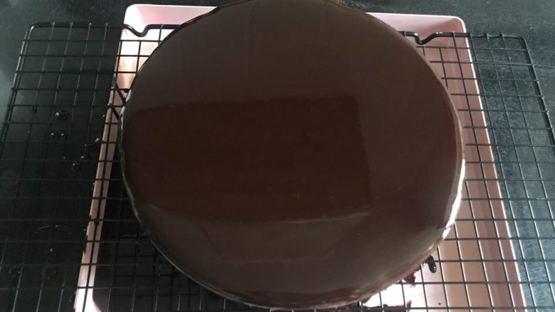 八寸巧克力慕斯巧克力淋面裱花蛋糕,过筛好的淋面液放凉到温热，不能感觉烫，大概四十多度，就可以淋了，要快，一气呵成。