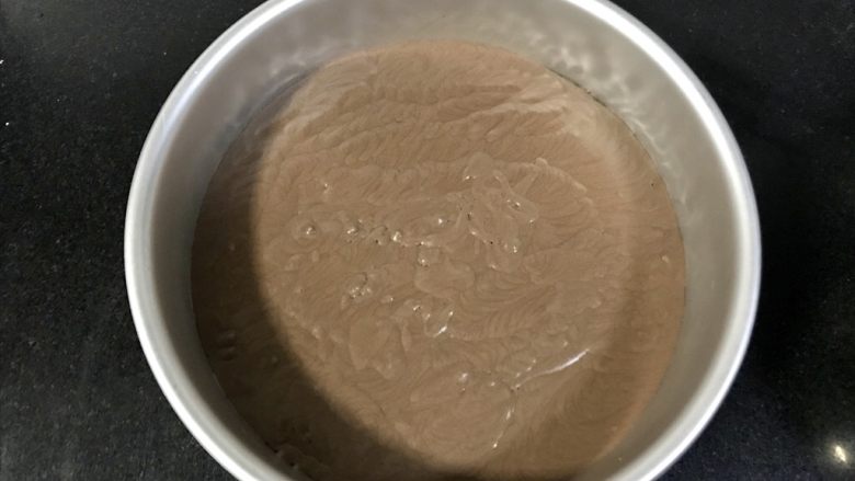 八寸巧克力慕斯巧克力淋面裱花蛋糕,从冰箱拿出来后放入一半的慕斯液，再铺一片戚风蛋糕片，冷藏半小时。