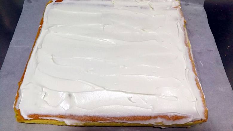  长颈鹿纹蛋糕卷,底部重新铺一张油纸，蛋糕再倒扣过来，有花纹的一面在下，蛋糕尾部切一斜边。奶油加糖打8分发，辅到没有图案的那一面，尾部涂薄一点。(这一步忘记拍图了用原味蛋糕片的图代替)