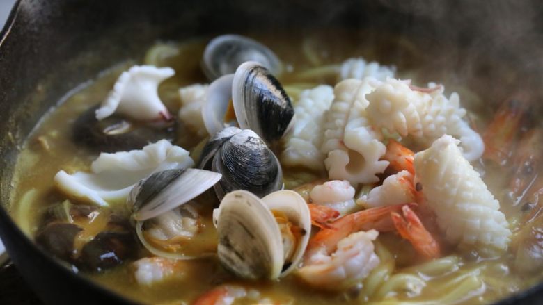 海鲜咖喱乌冬面,等汤汁变略浓稠，放入鱿鱼、虾、文蛤煮一二分钟，挑出虾头。