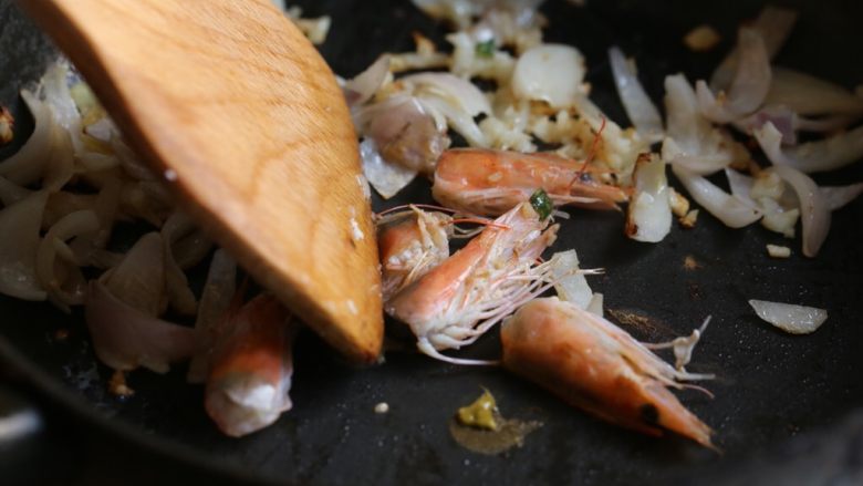 海鲜咖喱乌冬面,放入虾头煸炒，用铲按压虾头出虾油。