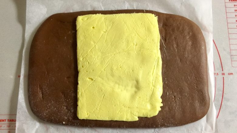 网红甜品+脏脏包,面皮冷冻好之后，取出，同时取出黄油片，撕去烘焙纸和保鲜袋，把黄油放在面皮中间。