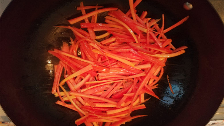 胡萝卜黄瓜丝,锅中放油，倒入胡萝卜。翻炒两分钟。