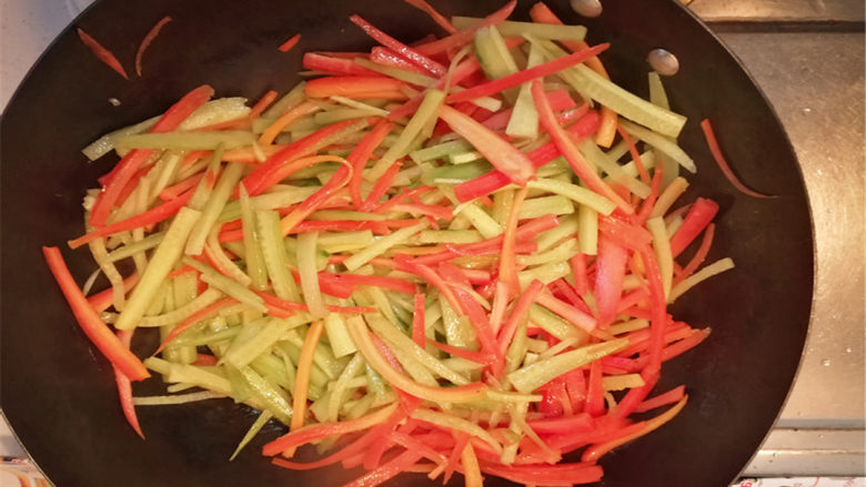 胡萝卜黄瓜丝,再倒入黄瓜丝，一起翻炒。放一点点水，盖上锅盖，焖两分钟。
