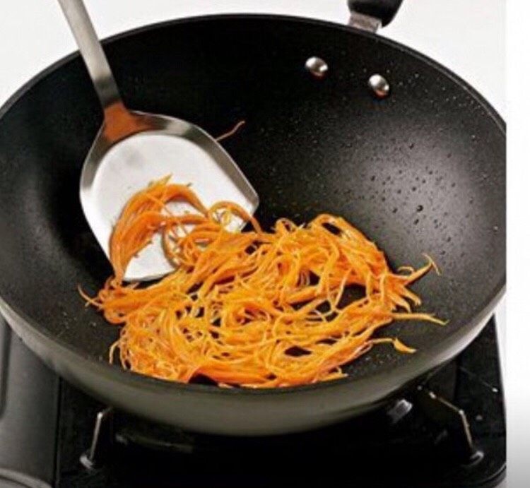 锅包肉,锅中留少量的底油，然后倒入胡萝卜丝，翻炒均匀。