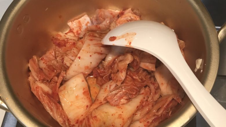 辣白菜豆腐汤,锅里放入猪肉，后放入辣白菜，翻炒。