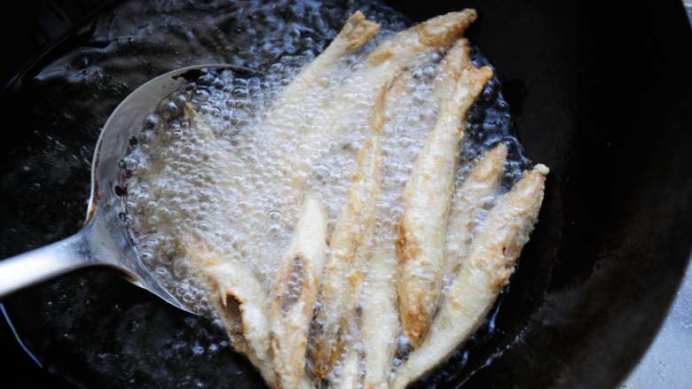干炸黄金沙丁鱼  外酥里嫩色泽金黄营养好,用漏勺翻动下锅内的鱼，以便炸的比较均匀。