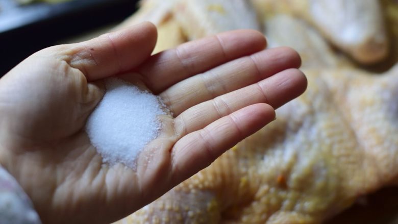 简单版鲜嫩烤全鸡,用纸巾将鸡抹干，取7克盐，均匀抹在鸡表面，正反两面都要抹。细致地按摩一两分钟。