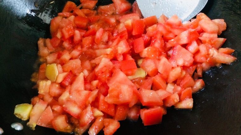 番茄营养排骨火锅,另起锅，放油，下西红柿丁和姜片一起翻炒。