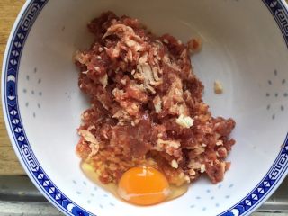 牛肉馅饼,肉馅放入碗内，打入一个鸡蛋，搅拌均匀
