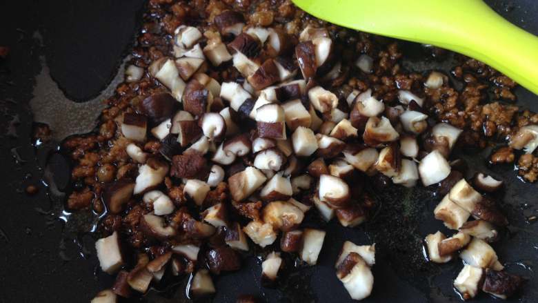 温州糯米饭,倒入香菇丁和盐，煸炒1分钟
