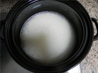 腊肠煲仔饭,浸泡好的大米，加入半汤匙色拉油拌匀，再加清水到食指第一关节的3/4处 。