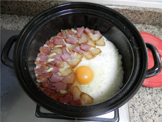 腊肠煲仔饭,在米饭表面铺上：腊肠和姜丝，再打个鸡蛋进去。