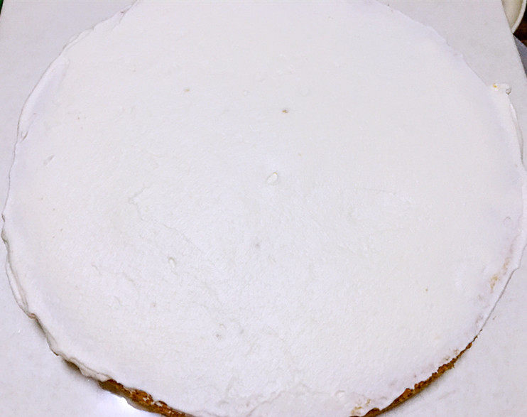 平安夜淋面蛋糕,将一片蛋糕放在底托上，抹上一层奶油。