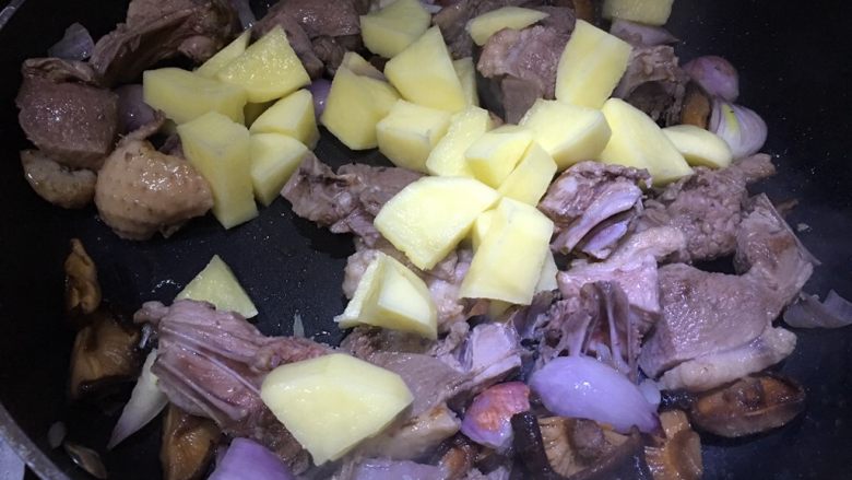 土豆香菇焖鸭肉,倒入土豆一起翻炒