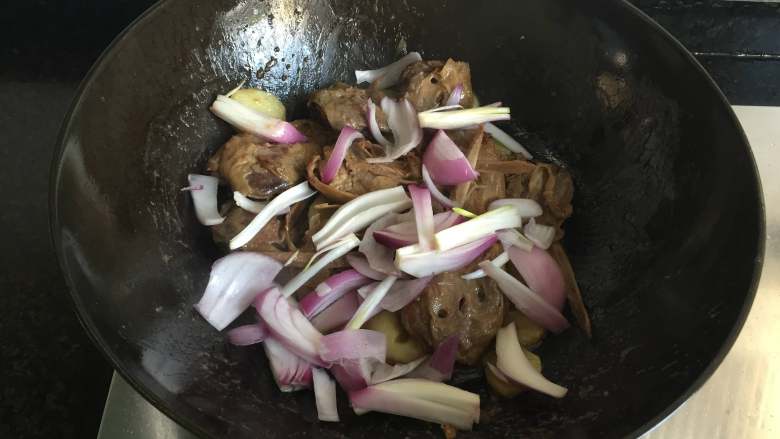 干锅土豆鸭头,汤汁快干的时候撒入洋葱翻炒熟出锅，撒上适量葱花点缀即可；