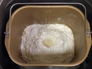 圣诞面包史多伦,除黄油以外的面包材料都放入面包机内（先液体后粉类的顺序），在面粉中间挖个洞，把酵母粉倒入，启动和面程序。