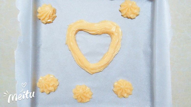 泡芙全家福,在金色烤盘上挤出自己喜欢的形状，我挤了一个心形和几个圆花型！