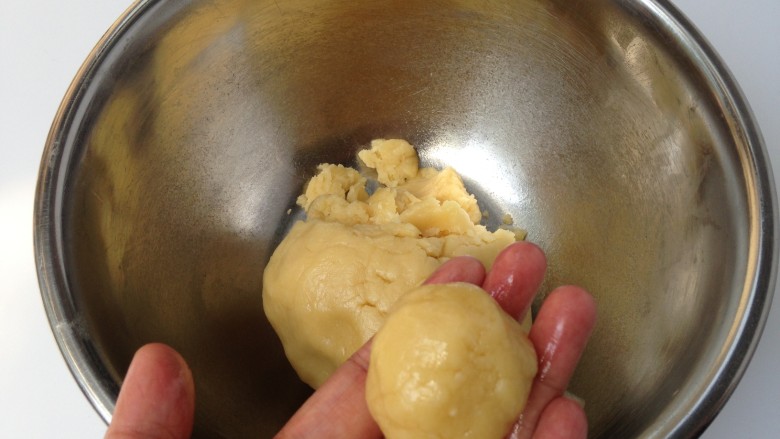 椰丝桃酥,用收揪取一个小面团，约20g左右，在手心搓圆